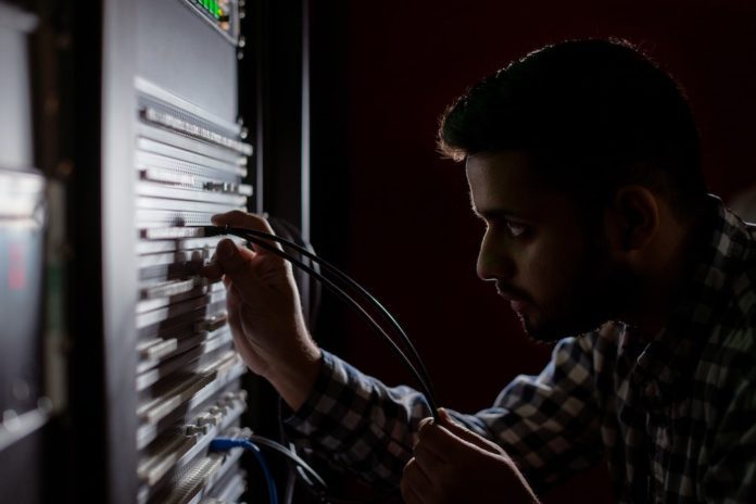 A data storage employee works on a server.